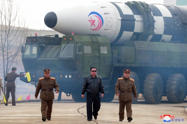 North Korean leader Kim Jong-un (center), accompanied by Jang Chang-ha (left), chief of the North`s Academy of National Defense, and Kim Jong-sik, the deputy director of the Munitions Industry Department, visits Pyongyang International Airport on Thursday to inspect the launch of a Hwasong-17 ICBM. (KCNA-Yonhap)