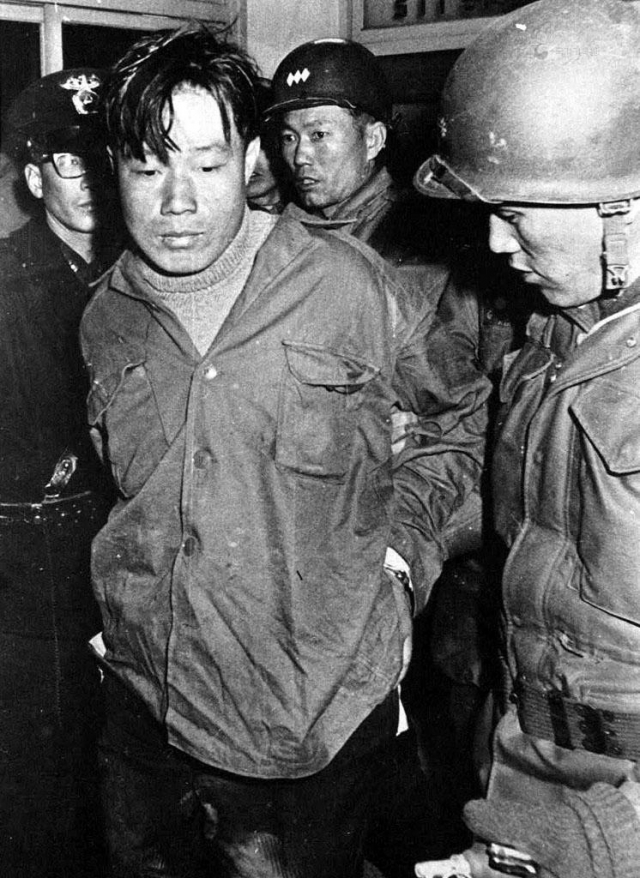 North Korean infiltrator Kim Sin-jo was captured alive and later defected to the South. This photo shows Kim being escorted from a police station on Jan. 22, 1968. (National Archives of Korea)