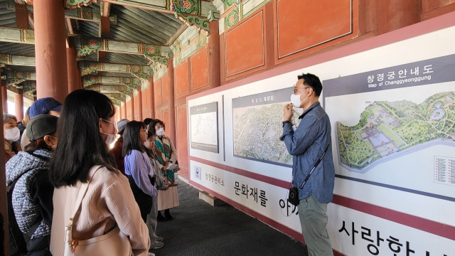 A cultural heritage commentator explains the buildings depicted in Donggwoldo at Changgyeonggung, Sunday. (Kim Hae-yeon/ The Korea Herald)