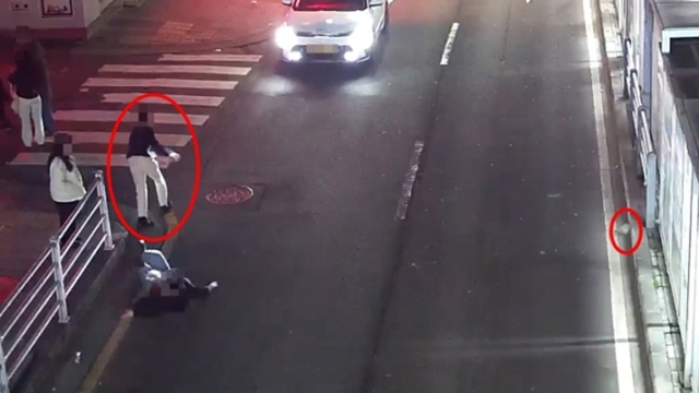 The suspect (left circle) runs away, leaving the victim lying in the road, after hitting him with a rock (right circle) in Jeju City, Jan. 31. (Jeju Dongbu Police Station)