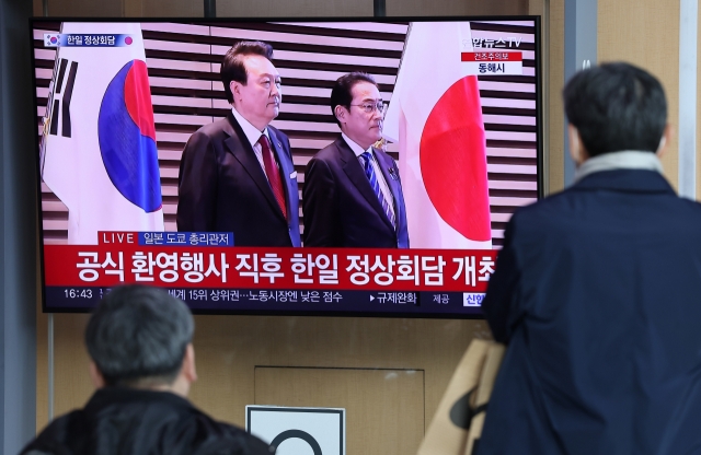 People watch breaking news on South Korea-Japan summit talks on a TV at Seoul Station on March 16, 2023. Earlier in the day, Yoon began a two-day trip to Japan for a summit with Japanese Prime Minister Fumio Kishida to put strained relations back on track. The summit marks the first time in 12 years that such talks have taken place amid tense relations between the two nations. (Yonhap)