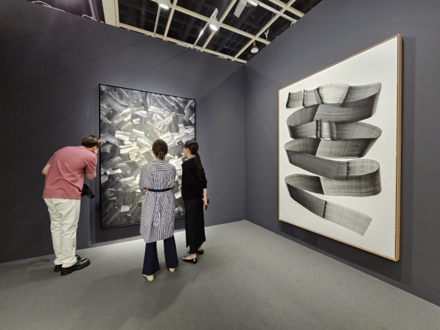 Visitors look at artwork by Korean painter Lee Bae presented by Johyun Gallery at Art Basel Hong Kong on Tuesday at the Hong Kong Convention and Exhibition Centre. (Park Yuna/The Korea Herald)