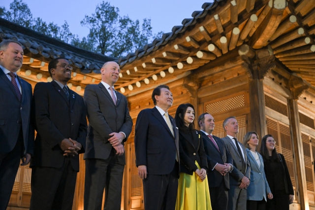 President Yoon Suk Yeol takes a commemorative photo before a welcome dinner with the BIE delegation who visited Korea for an inspection of Busan, a candidate site for the 2030 World Expo, at Cheong Wa Dae, the former presidential office and residence. (Yonhap)