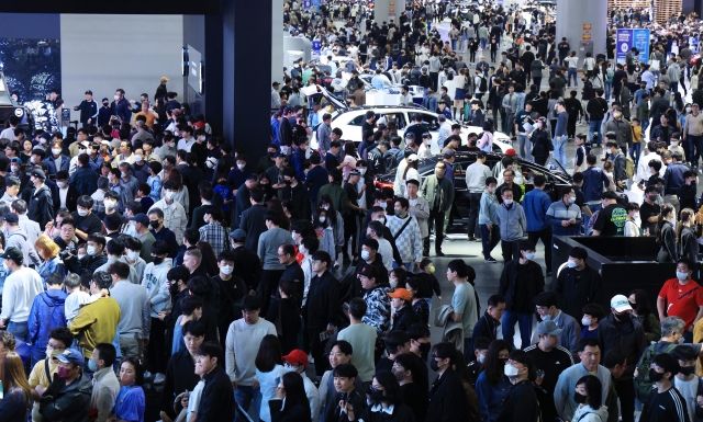 This photo taken on April 2 shows people looking at vehicles displayed at the Seoul Mobility Show at KINTEX exhibition hall in Goyang, just northwest of Seoul. (Yonhap)