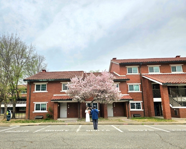 Hwang and her boyfriend participate in a wedding photo shoot against the backdrop of red brick townhouses, on April 4 (Choi Jae-hee / The Korea Herald)