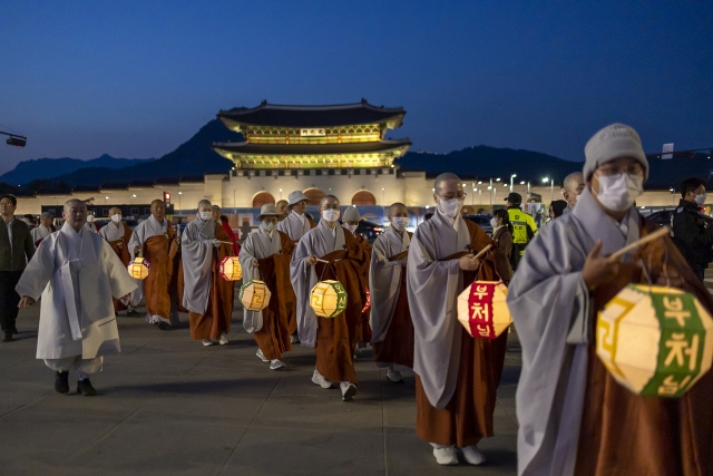 In this file photo, Buddhist monks circle a large pagoda-shaped lantern during a lighting ceremony at Gwanghwamun Square in Seoul on April 26, in preparation for Buddha's Birthday, which falls on May 27 this year. (Yonhap)