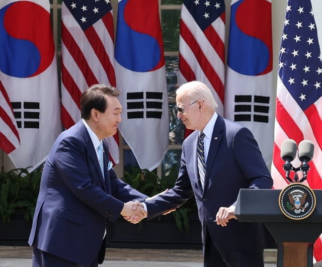 South Korean President Yoon Suk Yeol (left) shakes hands with US President Joe Biden during a joint news conference after their summit at the White House in Washington, DC, on last Wednesday (Yonhap)