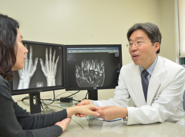 Dr. Bae Sang-cheol discusses a patient's condition at his office at Hanyang University Hospital for Rheumatic Diseases in Seoul. (Courtesy of Hanyang University Hospital for Rheumatic Diseases)