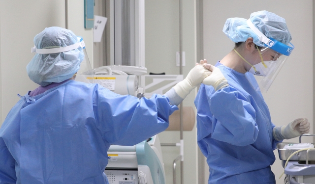 Medical workers high-five each other at a medical center in Daegu, about 240 kilometers southeast of Seoul, on Thursday. (Yonhap)