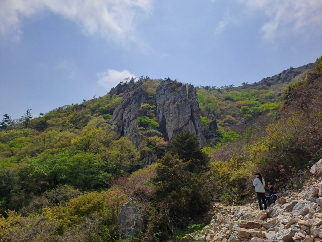 Hikers take a rest along a rock-covered slope or 