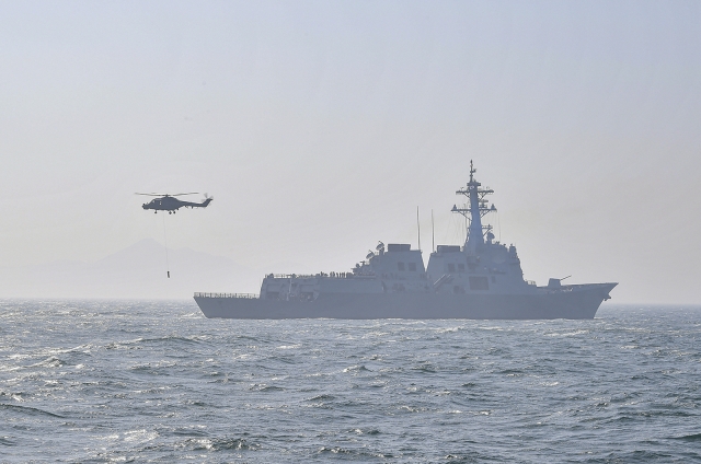 The South Korean Navy’s 7,600-ton Sejong the Great Aegis destroyer and Lynx multi-purpose military helicopter stage an anti-submarine warfare exercise on Tuesday in waters off the island of Gadeokdo in Busan. (Republic of Korea Navy)