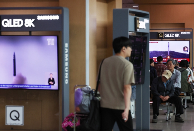 A commuter watches a TV report at Seoul Station, in the center of the capital, about North Korea's firing of what it claims to be a 