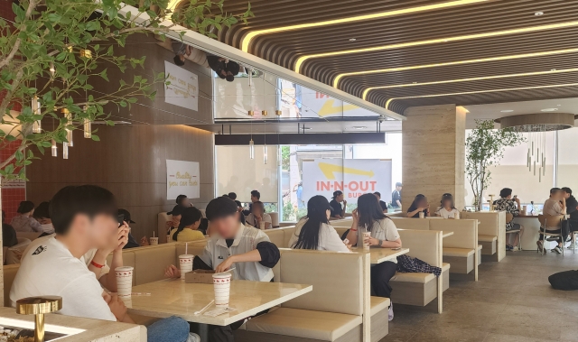 Customers try In-N-Out's burger products at the chain's pop-up store in Gangnam-gu, Seoul, Wednesday. (Lee Yoon-seo/The Korea Herald)