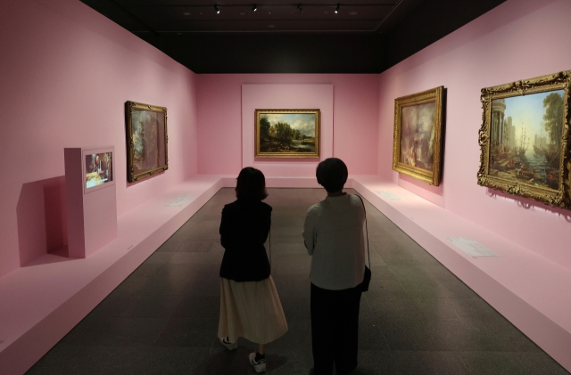 Visitors look at artwork at the exhibition 