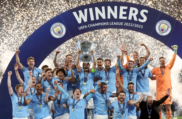 Manchester City captain Ilkay Guendogan raises the trophny as the team celebrate winning the UEFA Champions League Final soccer match between Manchester City and Inter Milan, in Istanbul, Turkey on Saturday. (EPA)