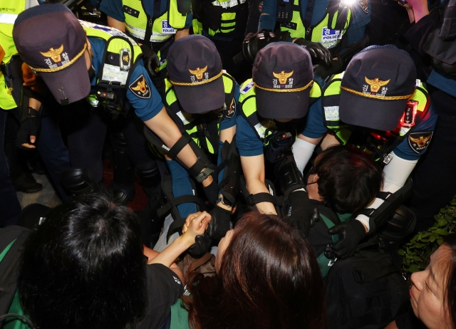 Police disband protestors dedicated to resolving the issue of irregular workers participating at a rally held outside the Supreme Court in Seoul’s Seochu-gu on Saturday. (Yonhap)