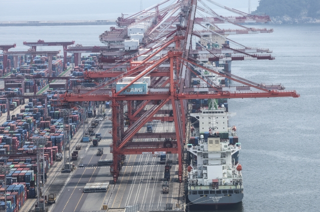 Containers for exports and imports are stacked at a pier under an overcast sky in South Korea's largest port city of Busan, 320 kilometers southeast of Seoul, on Monday. (Yonhap)