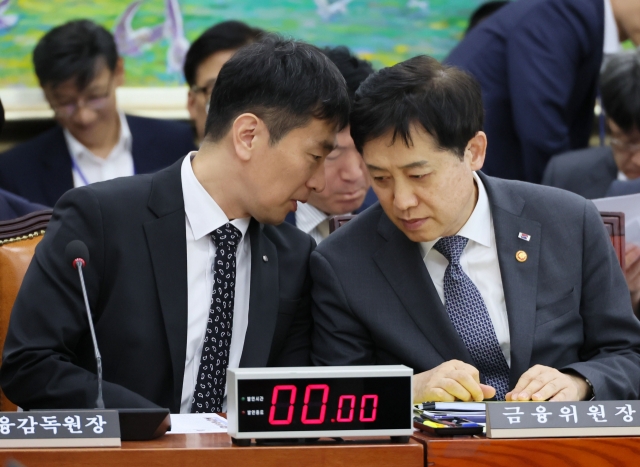 Lee Bok-hyun (left), head of the Financial Supervisory Service, talks with Kim Joo-hyeon, chairman of the Financial Services Commission, during a parliamentary session at the National Assembly in Seoul, Thursday. (Yonhap)