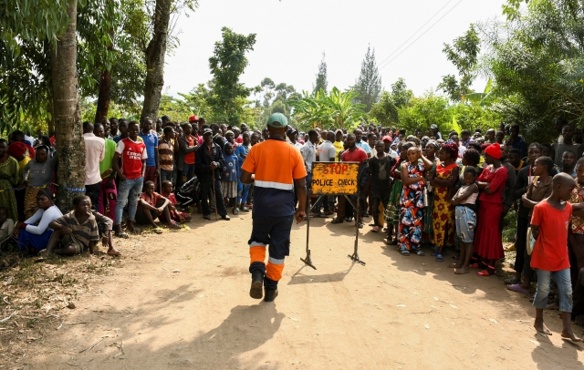 Locals gather at the cordoned scene outside the Mpondwe Lhubirira Secondary School, after militants linked to rebel group Allied Democratic Forces killed and abducted multiple people, in Mpondwe, western Uganda, Saturday. (REUTERS/Stringer)