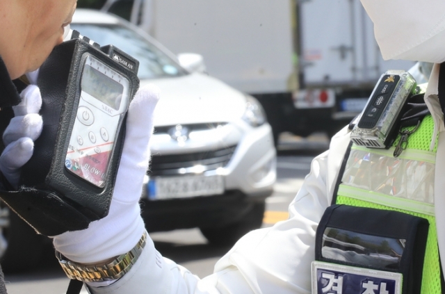 A police officer conducts a sobriety test on a driver in Seoul on April 20. (Yonhap)