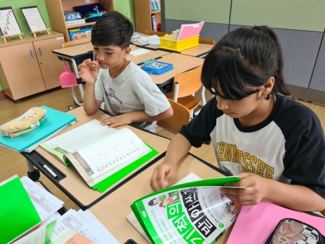 Marwa Sadiqi (right) and Sear Mirzaie participate in a dictation exercise in a Korean class for non-native speakers at Seoboo Elementary School in Ulsan, South Gyeongsang Province. (Kim So-hyun / The Korea Herald)