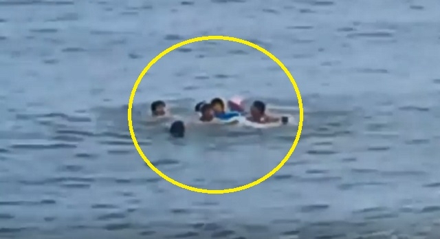 A screenshot of video footage from MBC where four foreigners rescue a grandmother in her 60s and his four-year-old grandson swept by waves at a beach in Donghae, Gangwon Province (MBC)