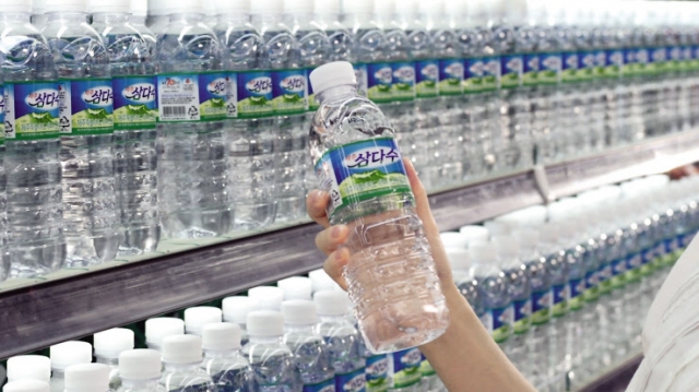 A person picks up a bottle of Jeju Samdasoo in a supermarket. (Jeju Special Self-Governing Province Development Co.)