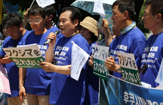 Democratic Party of Korea Rep. Ju Cheol-hyeon (third from left, front row) delivers a speech as they staged a protest with Japanese activists in front of Japanese Prime Minister Fumio Kishida's office in Tokyo on Monday. (Yonhap)