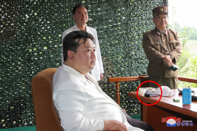 North Korean leader Kim Jong-un seen with a foldable phone that resembles Samsung's Galaxy Z Flip on Wednesday. (KCNA)