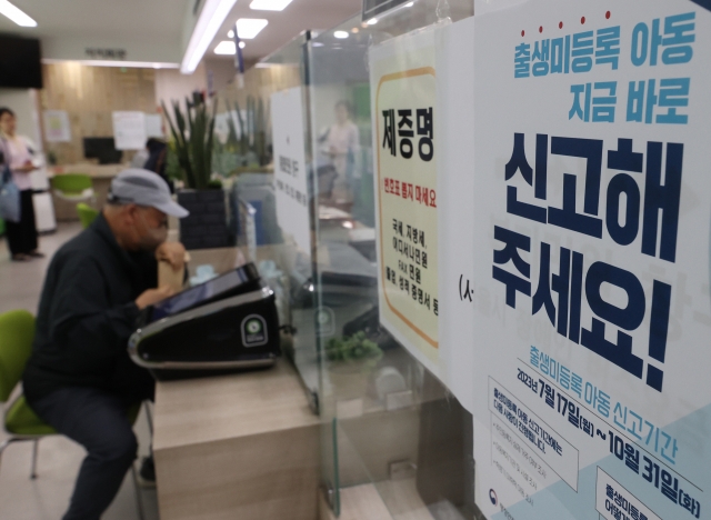 A poster asks people to report suspected cases of undocumented babies to authorities, from a community service center in the southeastern ward of Songpa in Seoul on Monday. (Yonhap)