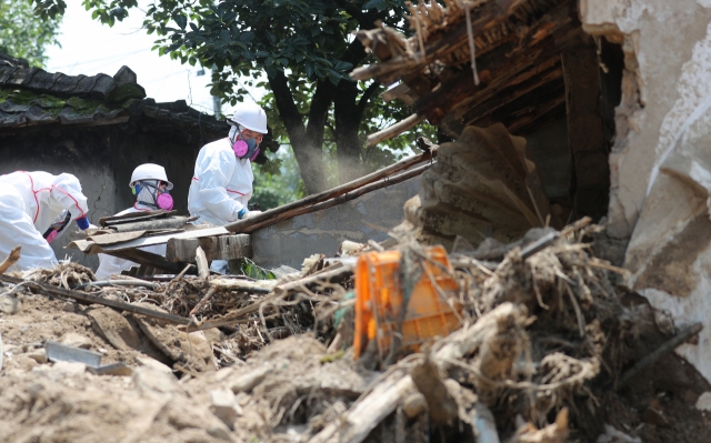 Yecheon-gun officials conducts restoration operation at the village hit by landslide during the downpour, Thursday. (Yonhap)