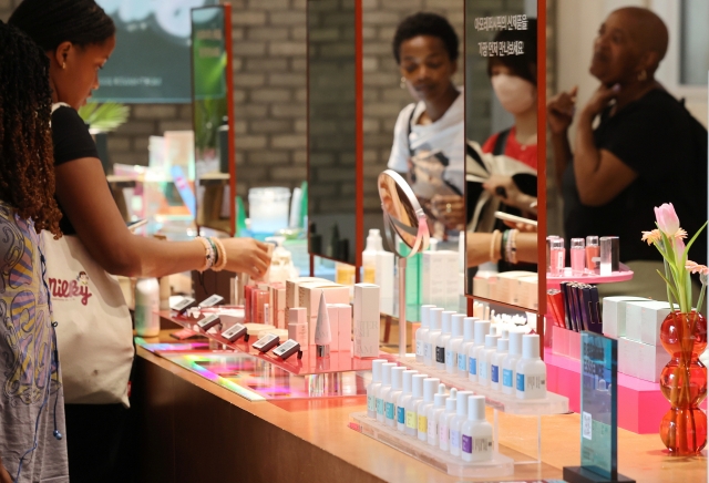 Foreign tourists test samples at a cosmetics store in Seoul on July 20, when the Korea Summer Beauty Sale, organized by the Culture and Tourism Ministry and Visit Korea Committee, kicked off for a one-month run, with 175 related companies joining. (Yonhap)