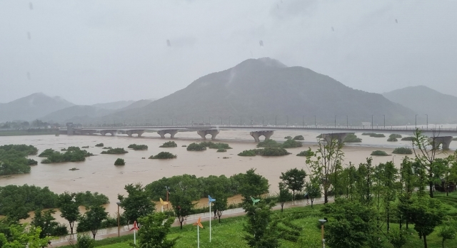 A river in the central city of Sejong overfloods due to torrential rain on July 15. (Yonhap)