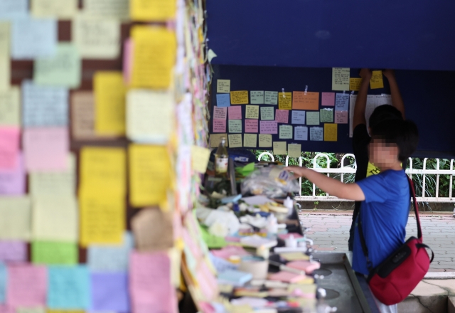 An elementary student on Tuesday pays his respects at a memorial set up for the 23-year-old elementary school teacher in Seoul’s Seocho-gu who took her own life last week. (Yonhap)