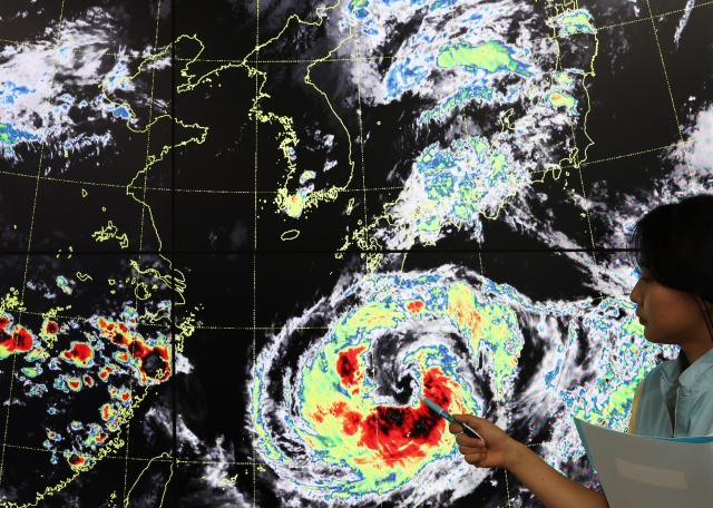 A weather agency official looks at the path of Typhoon Khanun at the weather office of the Seoul metropolitan area on Monday. The typhoon is expected to land on South Korea's southeastern coast later this week. (Yonhap)