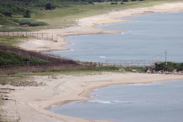 A chain-link fence that starts from a sandy beach on Korea's eastern shore splits into two barbed wire fences called the Korean Demilitarized Zone, separating the two Koreas for the past 70 years. Photo © Hyungwon Kang