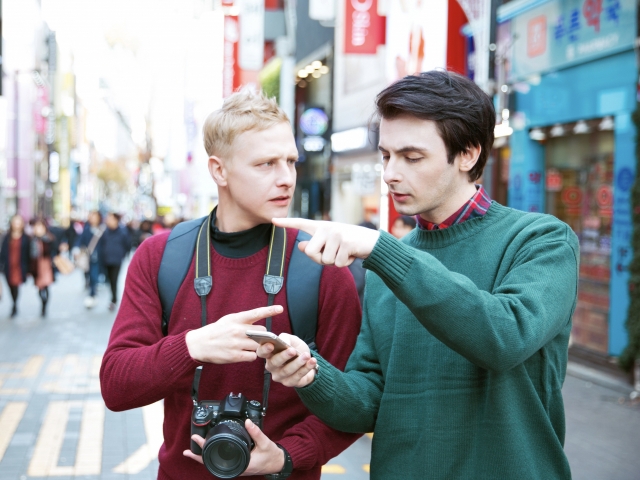 Foreign tourists turn to a smartphone for guidance in Myeongdong, Seoul. As tourism rebounds, shortcomings in the multi-lingual offerings of local alternatives Naver Map and Kakao Map stand out against the global standard set by Google Maps. (123rf)