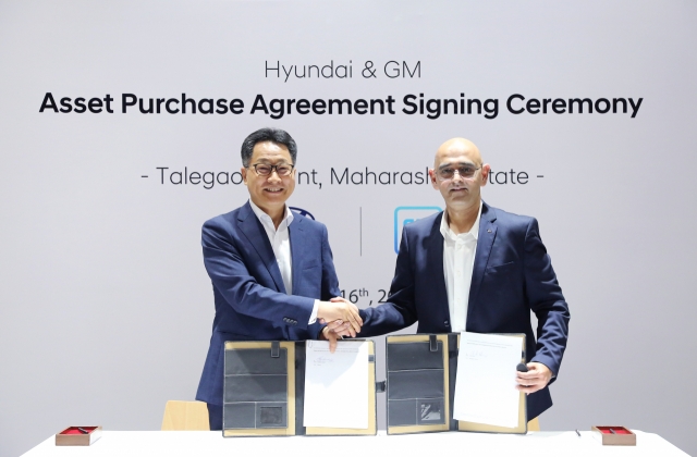 Kim Un-soo (left), CEO of Hyundai Motor India, and Asifhusen Khatri, vice president of General Motors India shake hands after announcing the signing of Hyundai Motor's asset purchase agreement of GM's Talegaon plant in Maharashtra on Wednesday. (Hyundai Motor Group)