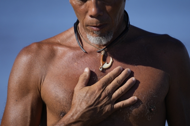 Vicente Ruboi stands on the shoreline after performing a blessing to greet the day, Tuesday, Aug. 15, 2023, in Kihei, Hawaii, following wildfires that ravaged Maui. (AP Photo/Rick Bowmer)