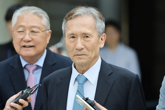 Former Defense Minister Kim Kwan-jin (second from left) heads out of Seoul High Court after a ruling that convicted him of political interference on Friday. (Yonhap)