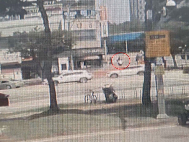 This photo shows the suspect in the red circle in a credit union heist in the central city of Daejeon on Aug. 18, riding a motorcycle before the crime. (Yonhap)