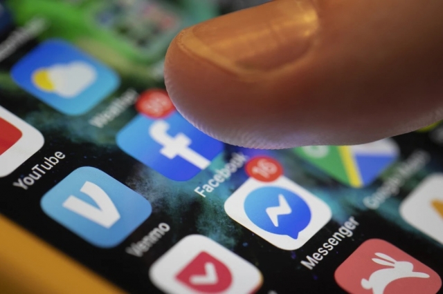 A smartphone displays the apps for Facebook and Messenger in New Orleans, Aug. 11, 2019. The European Union on Wednesday targeted Apple, Amazon, Microsoft, Google parent Alphabet, Facebook owner Meta and TikTok parent ByteDance under new digital rules aimed at reining in the market power of online companies. (AP Photo/Jenny Kane, File)