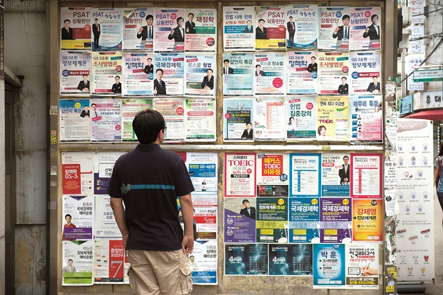 This undated photo shows a man looking at cram school posters in Sillim-dong. (Seoul Museum of History)