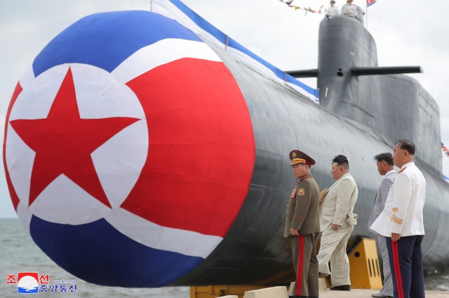 North Korean leader Kim Jong-un (2nd from left) attending the commissioning ceremony on Wednesday of a newly built 