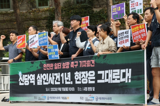 Union members and civic activists chant slogans at a press conference, holding a banner that reads 