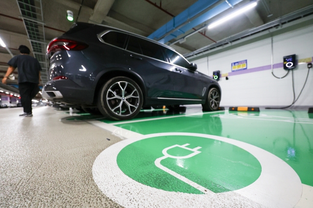 An EV is being charged in a parking lot in Seoul. (Yonhap)