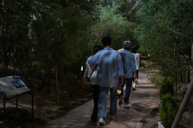 Visitors carrying small lanterns enjoy a stroll through the Mediterranean greenhouse on Sept. 8. (Lee Si-jin/The Korea Herald)