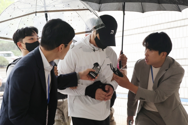 A 30-year-old suspect, identified by his surname Hong and accused of threatening another driver with a weapon over a parking space dispute, enters a Seoul court to attend an arrest warrant hearing on September 13. (Yonhap)