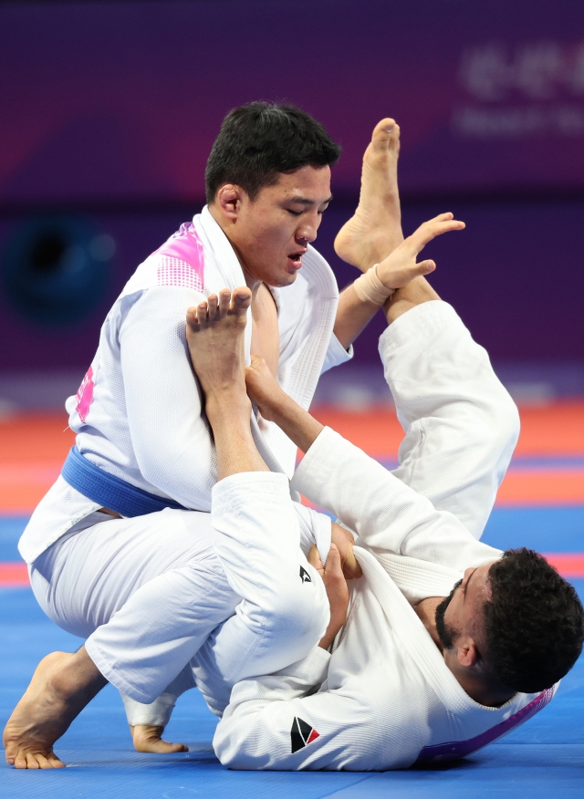 Koo Bon-cheol of South Korea (top) competes in the final of the men's -77-kilogram event in ju-jitsu against Ali Seena Ebrahim Abdulla Munfaredi of Bahrain at the Asian Games at Xiaoshan Linpu Gymnasium in Hangzhou, China, on Oct. 6, 2023. (Yonhap)