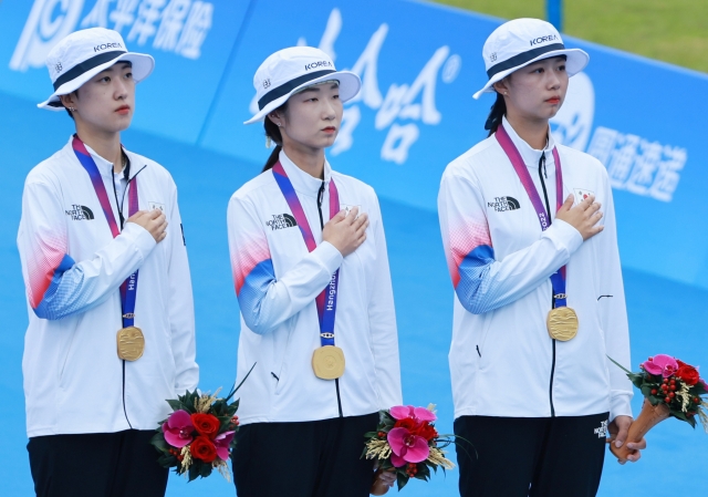 An san (left), Choi Mi-sun (center) and Lim Si-hyeon of the South Korean women's archery team participate in the medal ceremony of the team recurve archery event of the 19th Asian Games in Hanzhou, China, on Saturday. (Yonhap)